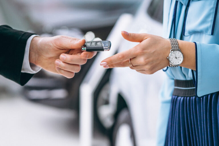 Man hands car keys to a woman