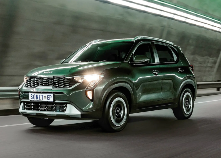 Green Kia Sonet SUV driving at speed on a highway with motion blur and illuminated headlights.